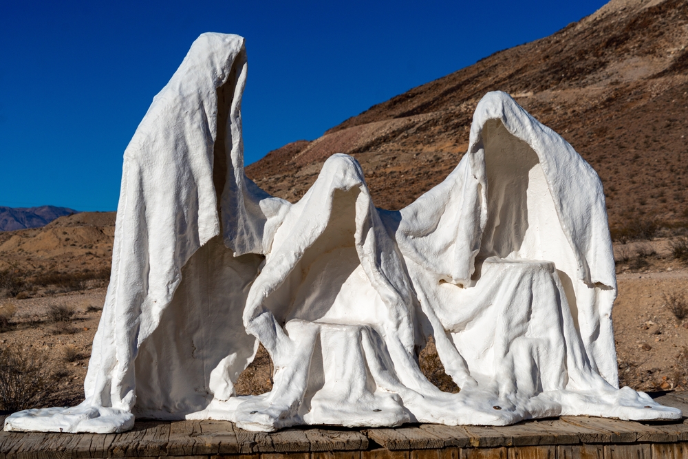 Rhyolite, Nevada USA - October 19, 2021: Plaster Ghost Statues in the desert at Rhyolite. Rhyolite is a former mining town that is now a Ghost town just outside of Death Valley National Park/Shutterstock