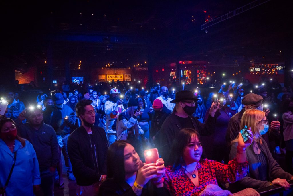 crowd with phone lights at hip-hop and poetry night