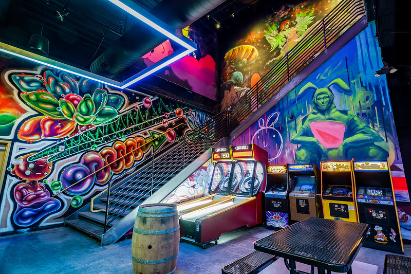 Inside the Emporium gaming arcade and bar showing stairs and arcade cabinets