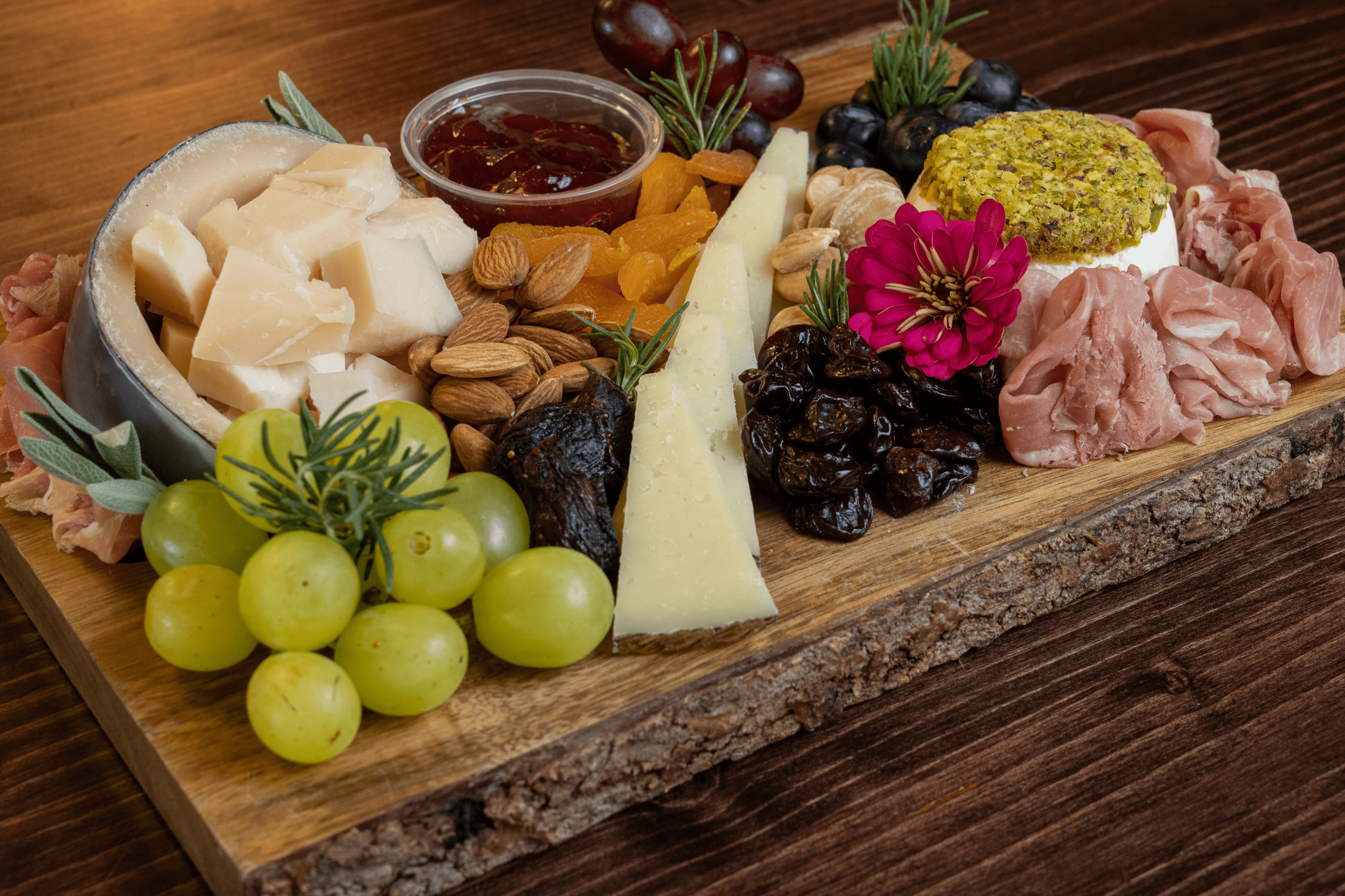 charcuterie board spread with grapes, almonds, cheeses, prosciutto and more of Valley Wine and Cheese - Diana Brier article