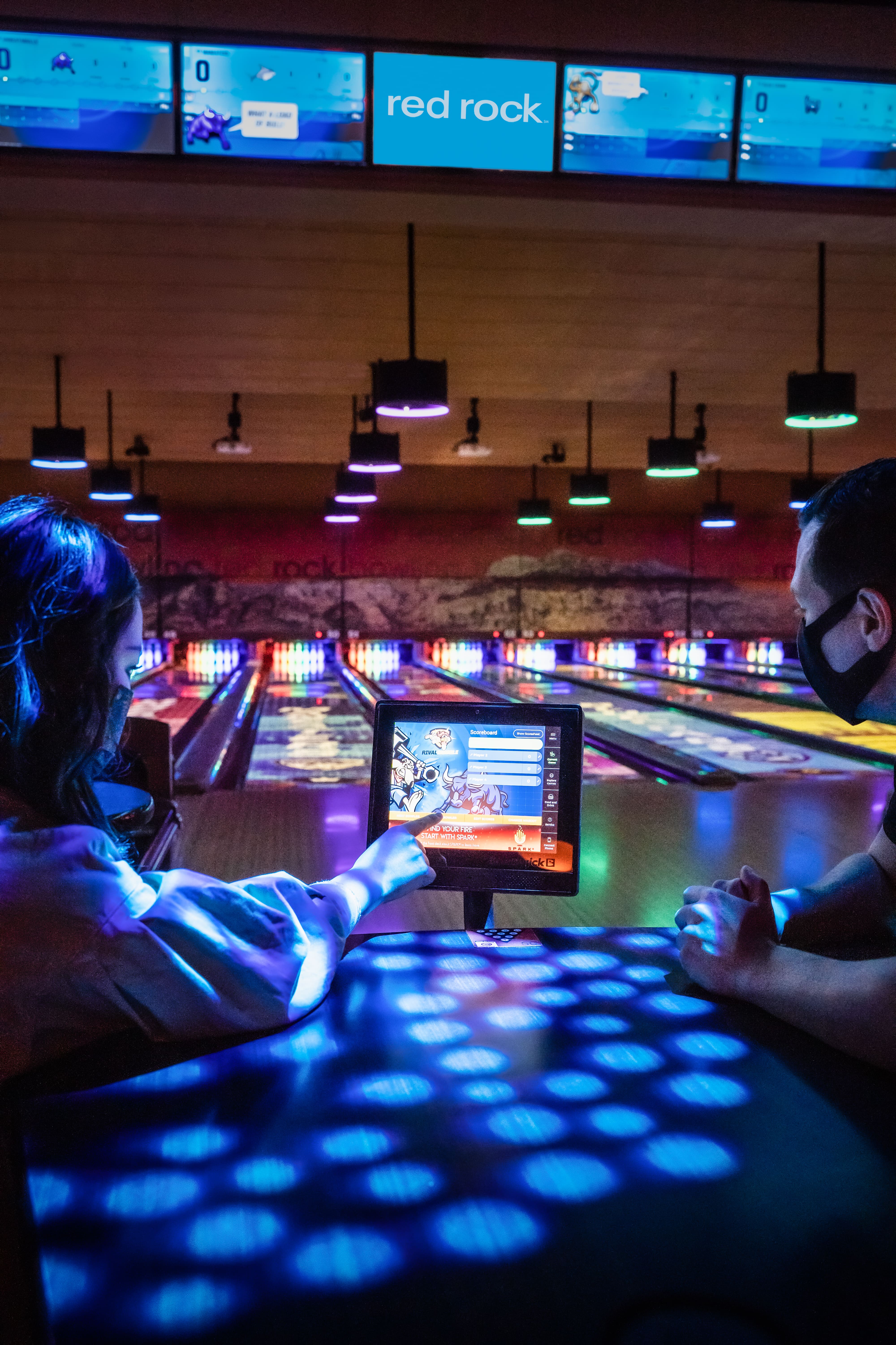 Bowlers at lane on tablet playing Spark Light It Up at Red Rock Lanes