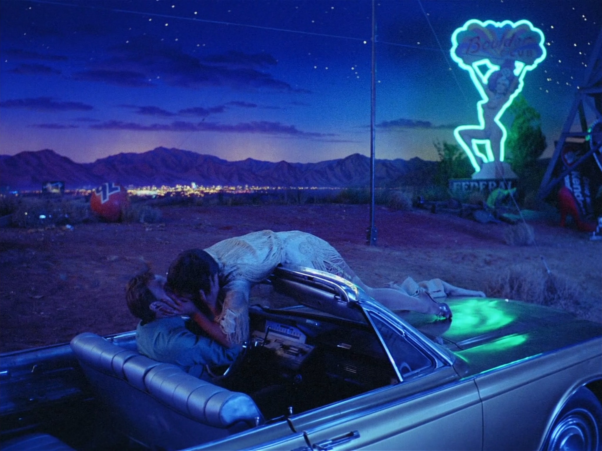 Las Vegas romantic musical from 1982 by Francis Ford Coppola - movie still of couple kissing in car by near neon showgirl sign