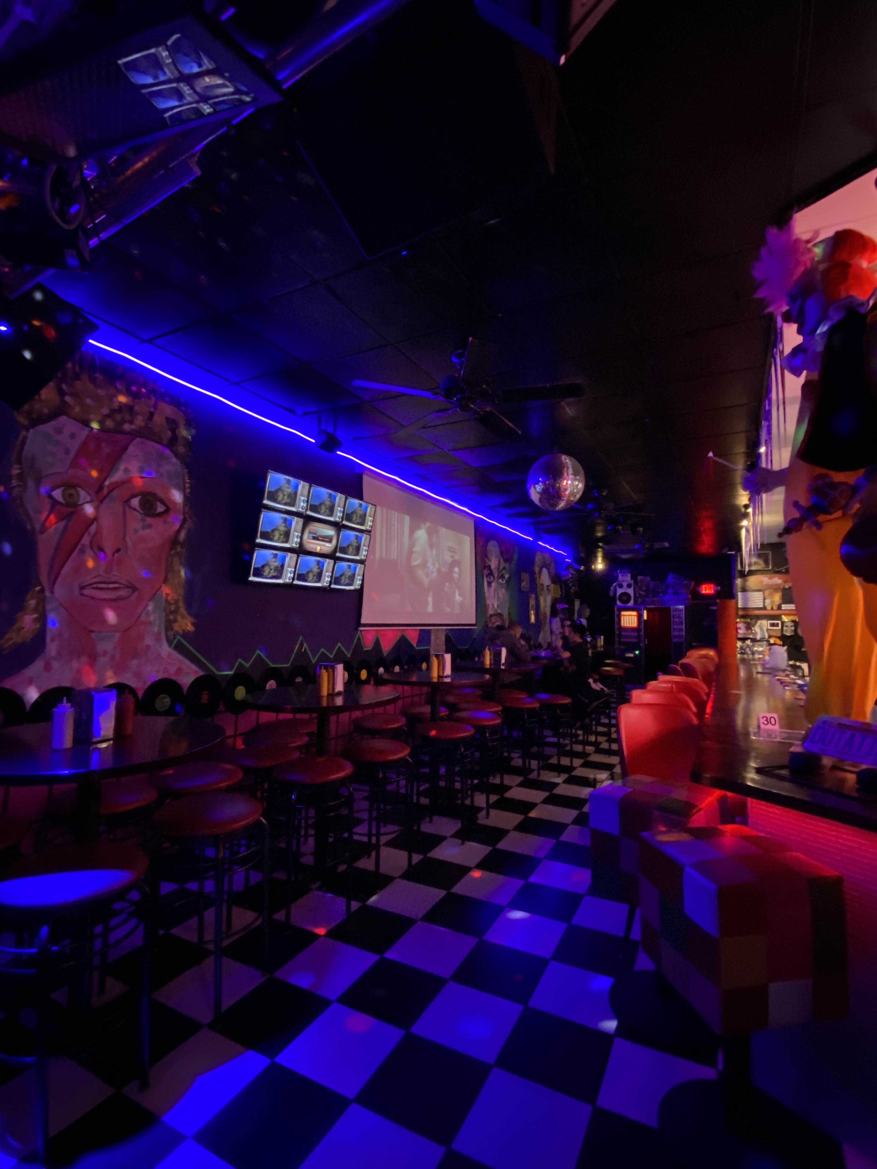 Back to the 80s Cafe and More bar - blacklight, mural of David Bowie, black and white checkered floors