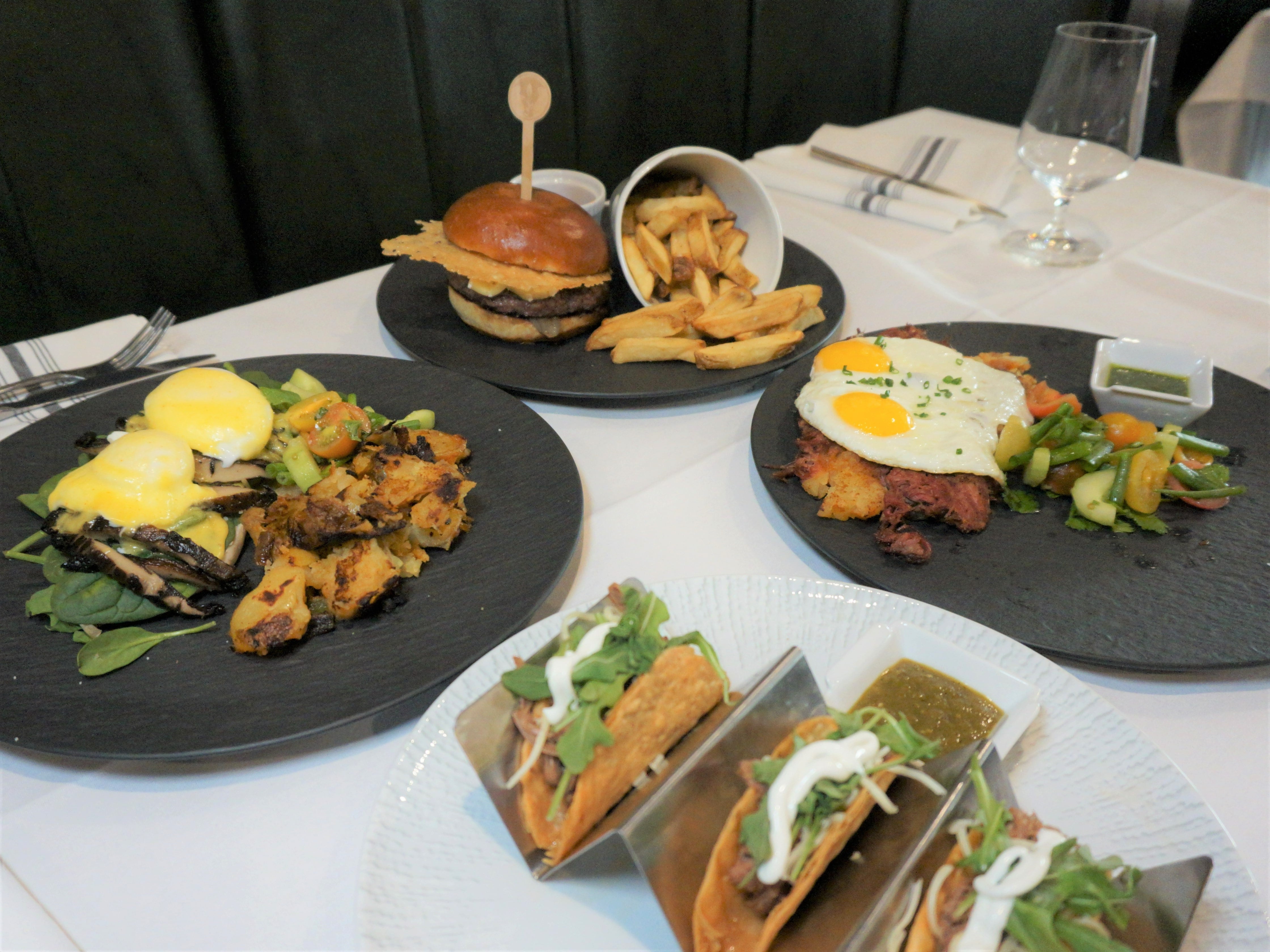 A tasty brunch spread with a burger combo, tacos, and egg dishes at 138° 