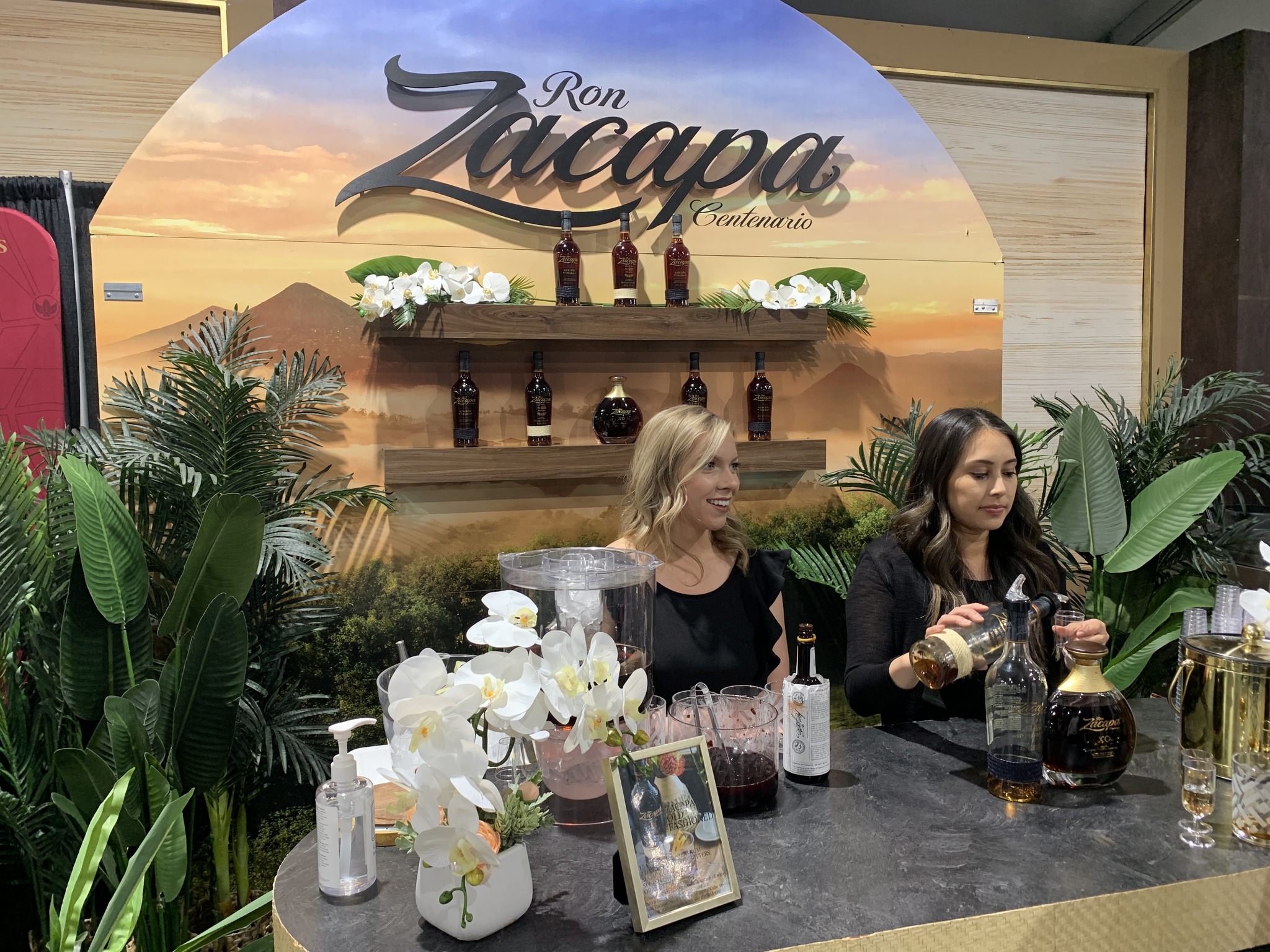 two girls pouring wine for Ron Zacapa